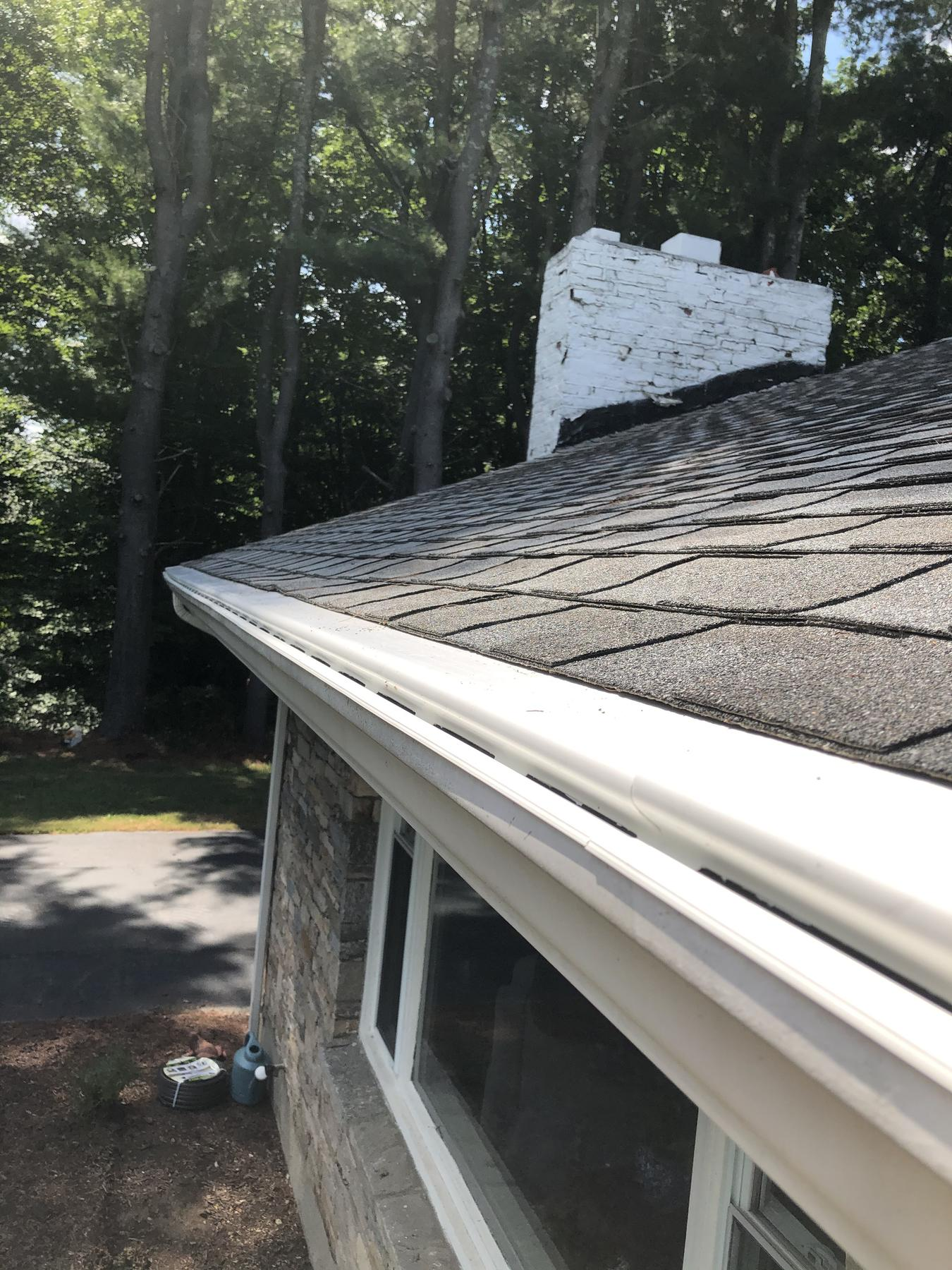 Reverse-curve gutter guard installed along a roof edge